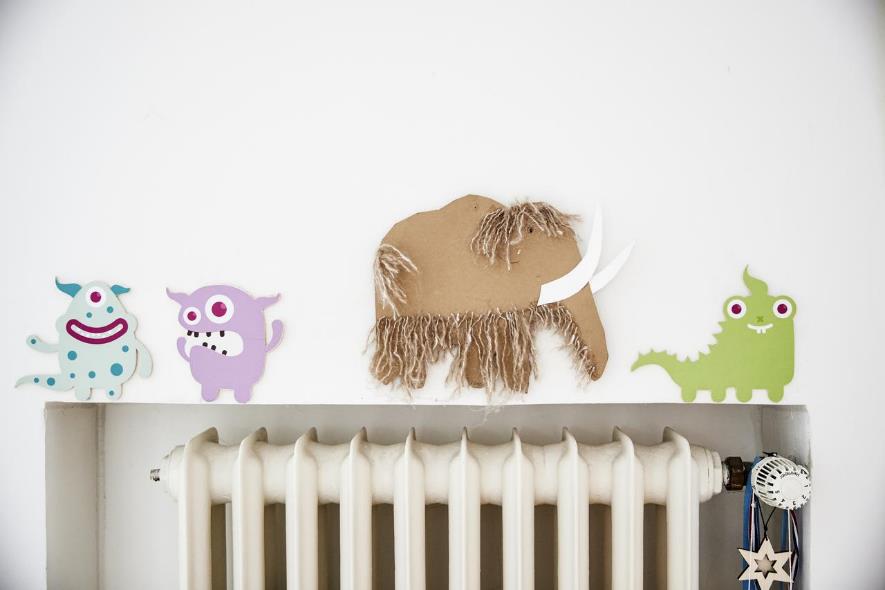 Heizung Kinder-Deko Foto einer Heizung, darüber gebastelte Pappfiguren an der Wand aufgeklebt